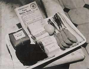 A ration book and a person's rations for a week - including four rashers of bacon and one egg.